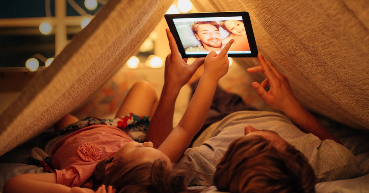 homem deitado em uma cama segurando um celular